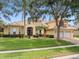 Inviting two-story yellow home featuring a tile roof, manicured lawn, and a two-car garage at 1319 Johns Cove Ln, Oakland, FL 34787