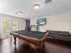 Bright game room with a billiard table, entertainment area, and French doors leading outside at 1319 Johns Cove Ln, Oakland, FL 34787
