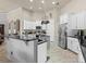 Modern kitchen featuring white cabinets, stainless steel appliances, an island, and an eat-in bar at 1319 Johns Cove Ln, Oakland, FL 34787