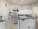 Spacious kitchen features white cabinetry, stainless steel appliances, tile flooring, and modern fixtures at 1319 Johns Cove Ln, Oakland, FL 34787