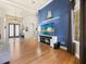 Contemporary living room with wood floors and a blue accent wall at 1319 Johns Cove Ln, Oakland, FL 34787