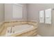 Bathroom features a white soaking tub with tile surround and decorative accent tile at 1403 Rolling Fairway Dr, Davenport, FL 33896