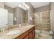 Bathroom showcases a tile shower, double vanity with granite, and tile flooring at 1403 Rolling Fairway Dr, Davenport, FL 33896