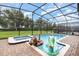 Screened-in pool with hot tub, lush landscaping, and brick pavers offering a private outdoor retreat at 1403 Rolling Fairway Dr, Davenport, FL 33896