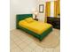 Staged bedroom features green bed frame, yellow bedding, and coordinating curtains at 141 Reserve Cir # 113, Oviedo, FL 32765