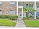 Well-maintained building entrance with brick accents, green shrubs, and walkway to first floor unit at 141 Reserve Cir # 113, Oviedo, FL 32765