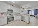 Well-lit kitchen featuring white cabinets, a breakfast bar, and stainless steel appliances at 141 Reserve Cir # 113, Oviedo, FL 32765
