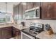 Modern kitchen with stainless steel oven, granite counters, and dark wood cabinetry at 15241 Sunrise Grove Ct, Winter Garden, FL 34787