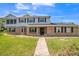 Two-story brick and siding home with a gray roof, dark shutters, and a sidewalk leading to the front door at 1601 Randolph St, Deltona, FL 32725
