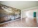 Open living room with laminate flooring, a large picture window, and a wall with a nature scene mural at 1601 Randolph St, Deltona, FL 32725