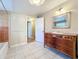 Bathroom with a tiled shower-tub, vanity, mirror, and doorway at 1840 Laurel Rd, Winter Park, FL 32789