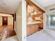 View of kitchen with light wood cabinets, breakfast bar, and tile floors, adjacent to a carpeted room at 1840 Laurel Rd, Winter Park, FL 32789