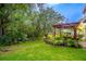 Lush backyard featuring a patio with a pergola, tropical landscaping, and a well-maintained lawn at 1933 Darlin Cir, Orlando, FL 32820