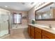 Bright bathroom featuring a glass shower, soaking tub, vanity with a large mirror, and neutral tile flooring at 1933 Darlin Cir, Orlando, FL 32820