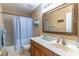 Cozy bathroom with a combination tub and shower, neutral walls, a vanity, and a large framed mirror at 1933 Darlin Cir, Orlando, FL 32820
