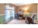 A well-lit room with two-tone painted walls, a window with privacy sheers, a desk and a cozy chair at 1933 Darlin Cir, Orlando, FL 32820