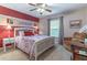 Charming bedroom featuring a white wood-framed bed, and neutral walls accented by a red wall at 1933 Darlin Cir, Orlando, FL 32820
