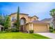 Charming two-story home featuring lush landscaping, arched entry and attached two car garage at 1933 Darlin Cir, Orlando, FL 32820