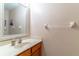 Cozy half bathroom with oak vanity, mirror, and white marble countertops at 1933 Darlin Cir, Orlando, FL 32820