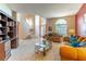 Sunlit living room featuring neutral tones, and large windows that showcase the front entryway and stairs at 1933 Darlin Cir, Orlando, FL 32820
