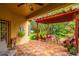 A covered patio with red pergola featuring tiled flooring, tropical landscaping, and red outdoor furniture at 1933 Darlin Cir, Orlando, FL 32820