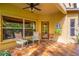 A covered tiled patio area with white chairs, an exterior door, and tropical plants and landscaping at 1933 Darlin Cir, Orlando, FL 32820