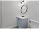 Cozy bathroom featuring a blue vanity, an oval mirror, and modern fixtures at 2 Rollingwood Trl, Deland, FL 32724
