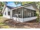 Exterior of the home featuring a screened patio area, surrounded by mature landscaping at 2 Rollingwood Trl, Deland, FL 32724