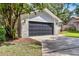 Home with garage door, stone accents, concrete driveway, and surrounding greenery at 2 Rollingwood Trl, Deland, FL 32724