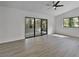 Spacious living room featuring a ceiling fan, sliding doors, and light laminate flooring at 2 Rollingwood Trl, Deland, FL 32724