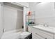 Well-lit bathroom featuring a shower-tub combo, single sink vanity, and three-shelf storage at 229 Bitterwood St, Winter Springs, FL 32708