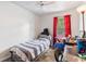 Cozy bedroom with a twin bed and a window with bright red curtains, offering a private retreat at 229 Bitterwood St, Winter Springs, FL 32708