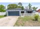 Charming single-story home with a modern garage door and a white picket fence surrounding the front yard at 229 Bitterwood St, Winter Springs, FL 32708