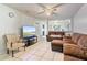 Bright living room with white tile floors, brown seating, ceiling fan and a view to the kitchen at 229 Bitterwood St, Winter Springs, FL 32708