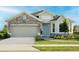Charming single-Gathering home featuring a stone facade, a two-car garage, and beautifully landscaped front yard at 2500 Raghav Trail Cir, Tavares, FL 32778