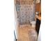 Full bathroom with a decorative shower curtain, tile flooring, and wood shelving for storage at 3074 Royal Tern Dr, Winter Haven, FL 33881