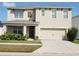 Two-story home featuring a two-car garage, neutral stucco, well manicured landscaping, and decorative shutters at 3074 Royal Tern Dr, Winter Haven, FL 33881