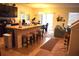 Open kitchen featuring counter seating, dark cabinets, stainless appliances, and view into the living space at 3074 Royal Tern Dr, Winter Haven, FL 33881