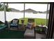 Screened patio featuring comfortable seating, decorative pillows, and a view of the fenced backyard at 3074 Royal Tern Dr, Winter Haven, FL 33881