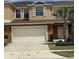Inviting townhouse featuring a two-car garage and lush landscaping at 3308 Rodrick Cir, Orlando, FL 32824
