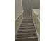 Carpeted stairway featuring white risers and railings, leading to the upper level at 3308 Rodrick Cir, Orlando, FL 32824