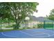 Community basketball court featuring bright blue surface, surrounded by a green fence and lush trees at 3372 Bellington Dr, Orlando, FL 32835