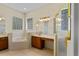 Well-lit bathroom with a garden tub, block glass windows, and vanity with dual sinks at 3372 Bellington Dr, Orlando, FL 32835