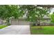 A three car garage is fronted by a spacious driveway and lush green lawn at 3372 Bellington Dr, Orlando, FL 32835