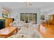 Living room featuring hardwood floors, large white sectional, and view of screened in pool at 3372 Bellington Dr, Orlando, FL 32835