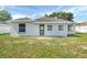 A rear view of the home featuring an open patio area and a well-maintained lawn at 340 Edgewood Ct, Kissimmee, FL 34759