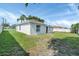 An open backyard with healthy green grass surrounding the white-walled house on a sunny day at 340 Edgewood Ct, Kissimmee, FL 34759