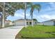 Well-maintained single-story home with lush lawn and two palm trees in front yard at 340 Edgewood Ct, Kissimmee, FL 34759