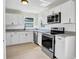 Modern kitchen with white cabinets, stainless steel appliances and tile backsplash at 340 Edgewood Ct, Kissimmee, FL 34759