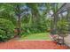 Wood-chipped backyard space offers privacy with mature green trees at 3593 Scoutoak Loop, Oviedo, FL 32765